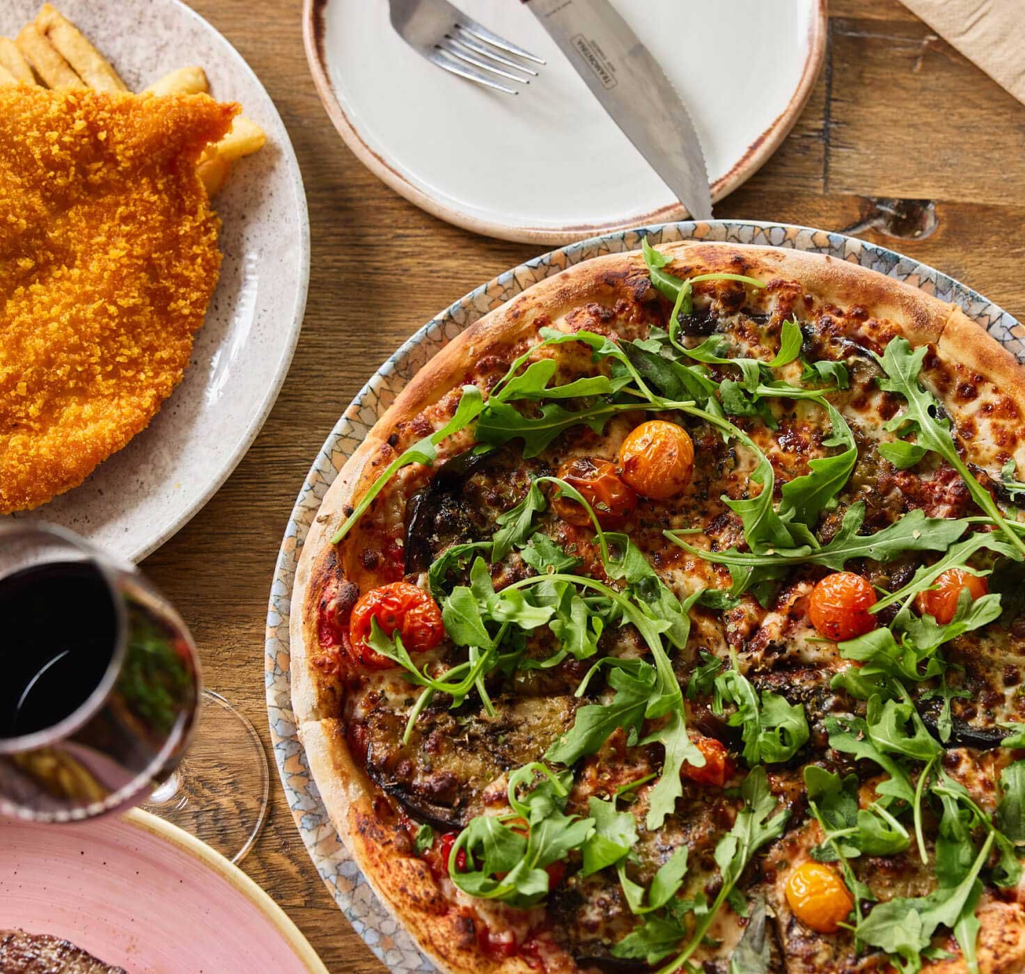 plated meals including a chicken schnitzel and pizza