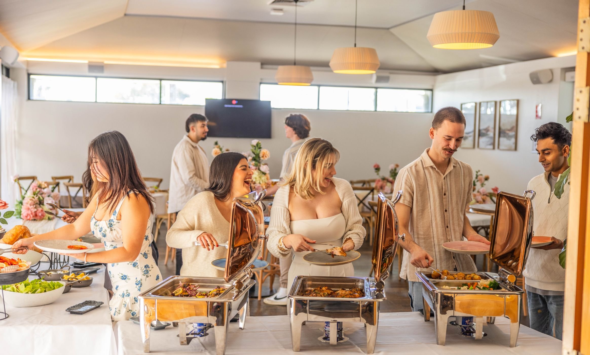 a group of people serving food from a buffet at a function